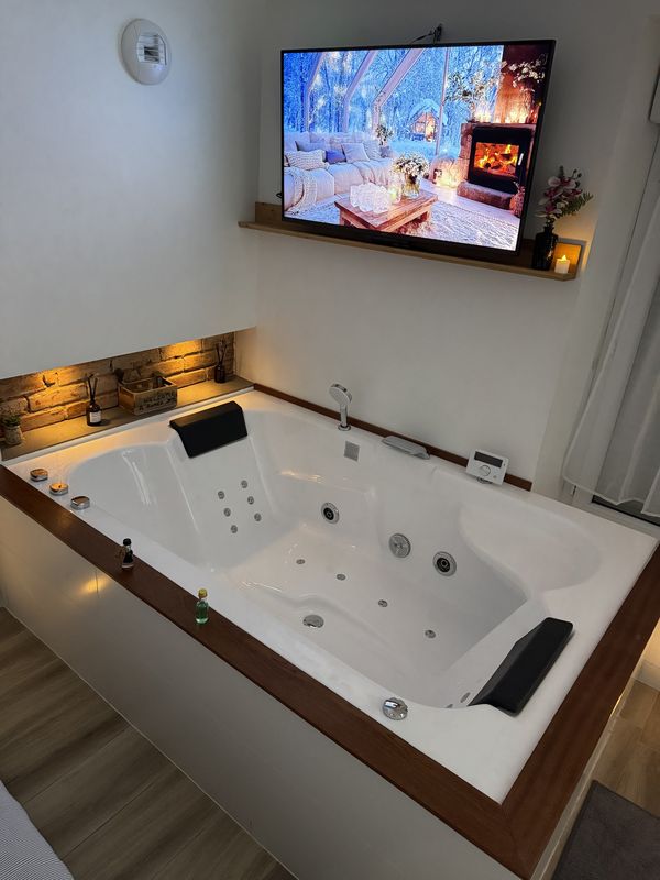Baignoire balnéo XXL de la suite Ô Roméo, écran avec feu de cheminée