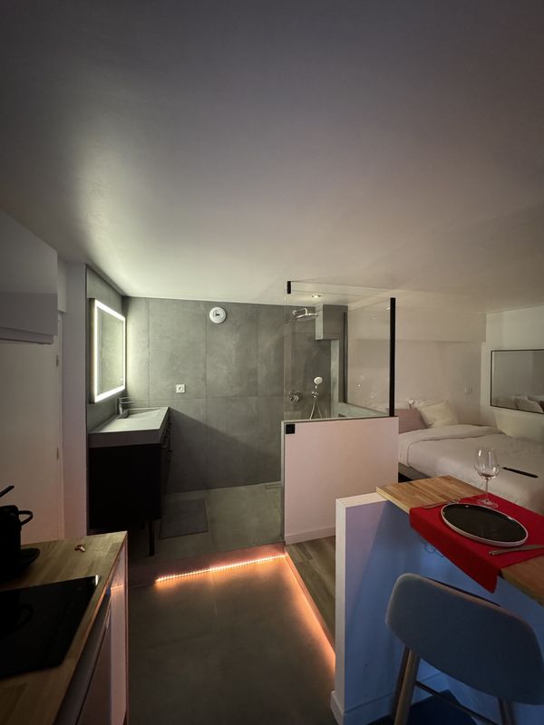 Salle de bain avec douche à l'italienne et vasque, éclairage tamisé